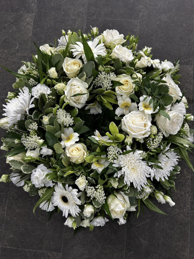 Classic Wreath in White -SYM-321 - This classic wreath made with mixed white and cream flowers is suitable for a lady or a gentleman. This type of funeral arrangement needs at least one working days’ notice for delivery. Same day delivery is not possible.