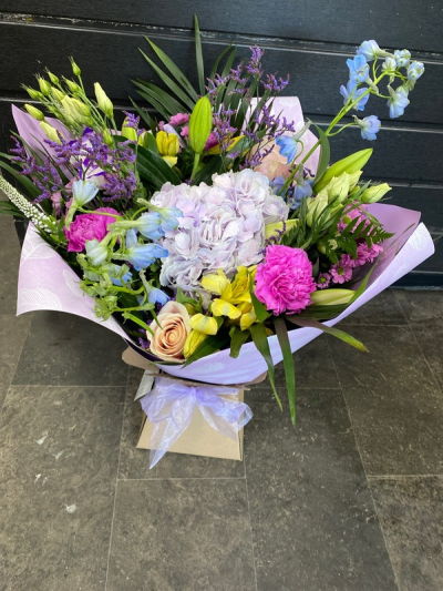 Hidden Treasure - An outstanding hand tied bouquet with a cascade of colour and a treasure chest overflowing with the beautiful flowers.