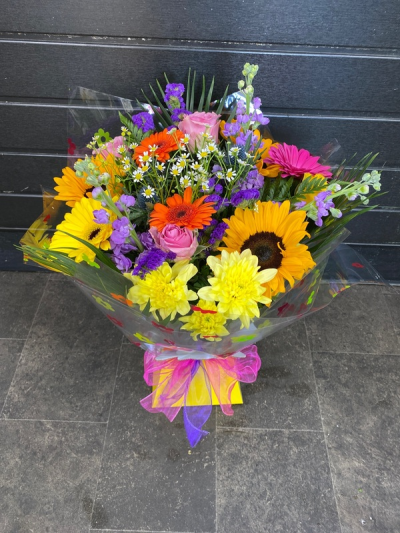 Bright Ideas - Beautiful Sunflowers and a peppering of other summer flowers and foliage. Tied in water and presented in a stylish bag. An amazing bouquet full of joy and delight ready to display and enjoy.